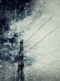 Electricity pylon against cloudy sky