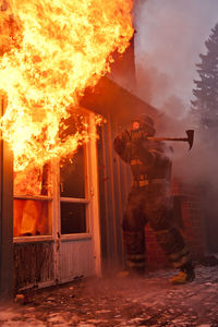 Fireman entering burning house