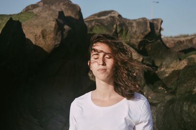 Young woman looking at rock