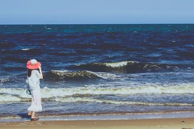 Rear view of woman standing on beach