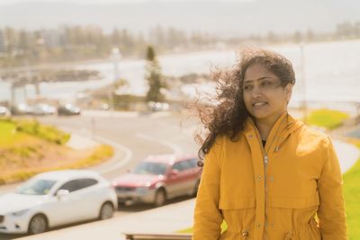 Portrait of smiling girl standing on road in city