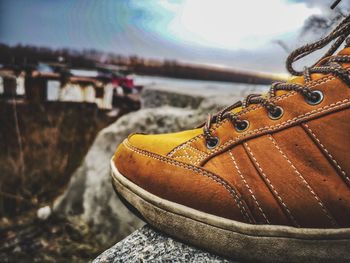 Close-up of shoes on riverbank