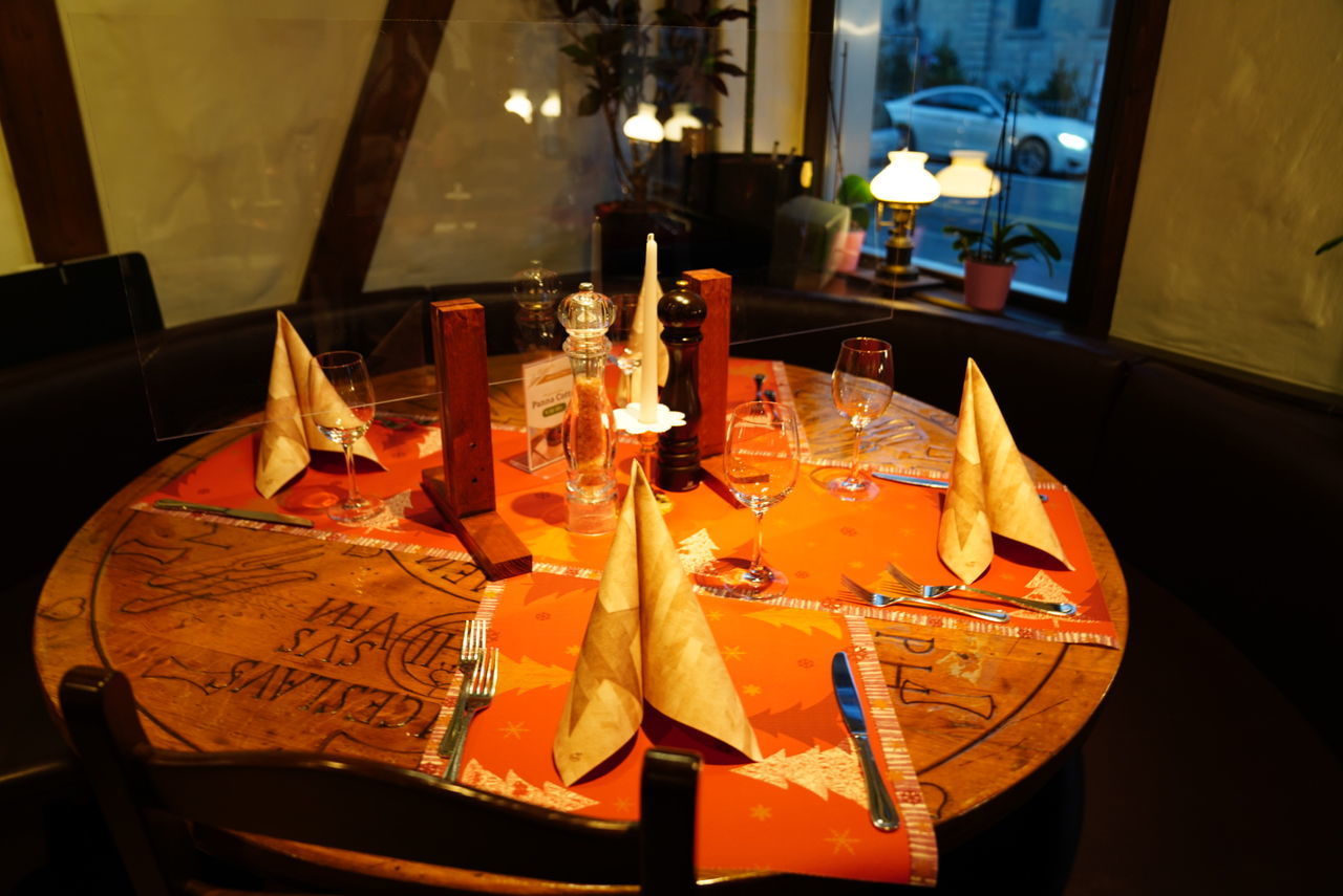 HIGH ANGLE VIEW OF WINE GLASSES ON TABLE IN RESTAURANT