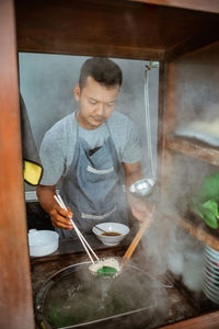 Portrait of boy preparing food in kitchen