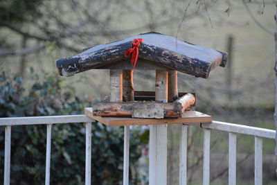 Abandoned birdhouse on railing outdoors