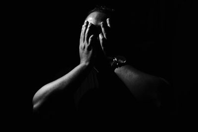 Close-up of man smoking over black background