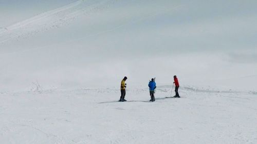 People walking on snow covered field