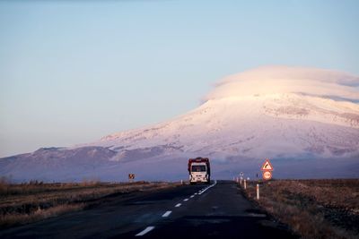 Road leading towards mountain against sky