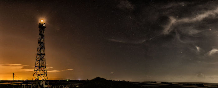 Panoramic shot of illuminated lighthouse against sky at dusk