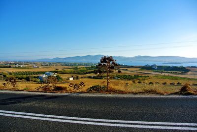 View of country road against cloudy sky