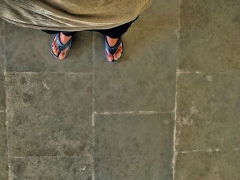 Low section of woman standing on tiled floor