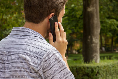 Rear view of man using mobile phone