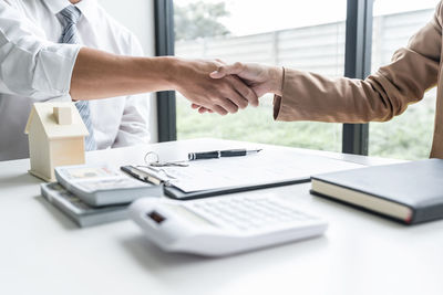 Cropped image of business colleagues shaking hands in office