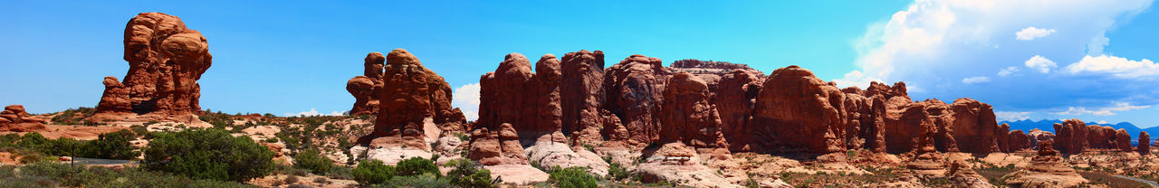 Panoramic view of rock formations against blue sky