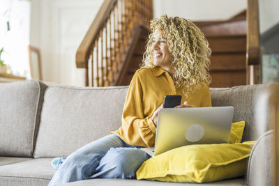 Woman sitting on sofa at home