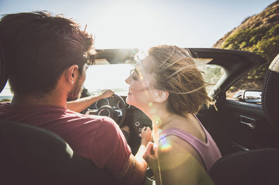 Rear view of couple sitting in car