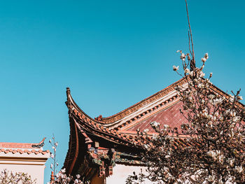 Low angle view of temple building against clear blue sky