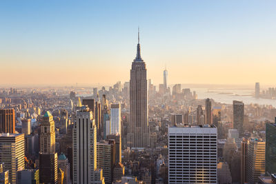 Aerial view of buildings in city against sky