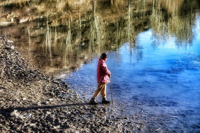 Rear view of man standing in water