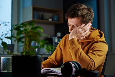 Tired man works late at workplace in the night