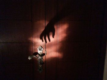 Low section of person with hand on curtain