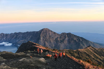 People on mountain peak during sunset