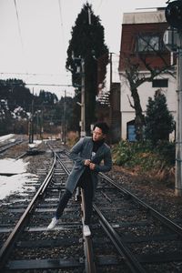 Man on railroad tracks against sky