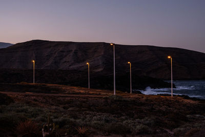 Scenic view of illuminated mountains against clear sky at night