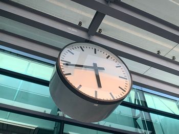 Low angle view of clock hanging on building