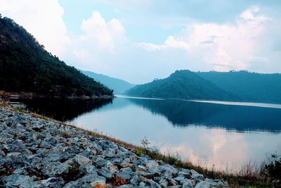 Scenic view of lake by mountains against sky