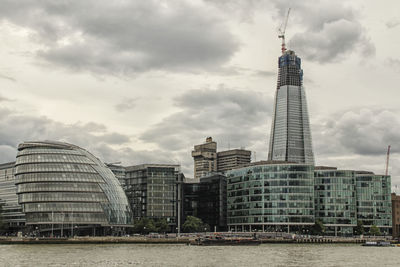 Low angle view of skyscrapers against cloudy sky