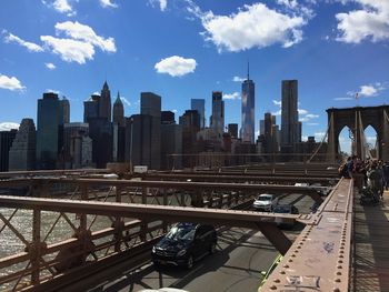 View of bridge in city against cloudy sky