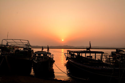 Boats sailing on sea against sky during sunset