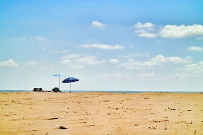 Scenic view of beach against blue sky