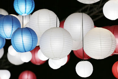 Low angle view of lanterns hanging against black background