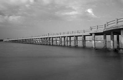 Bridge over calm sea against sky