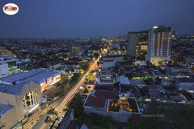 High angle view of illuminated buildings against sky at night