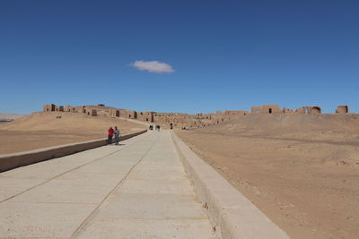 Panoramic view of people on beach against blue sky