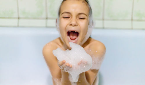 Portrait of cute girl washing hands in bathroom