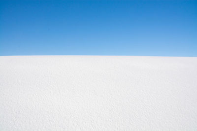 Scenic view of desert against clear blue sky