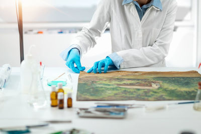 Oil painting restoration expert repairing damage on the canvas