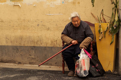 Portrait of man holding umbrella while standing outdoors