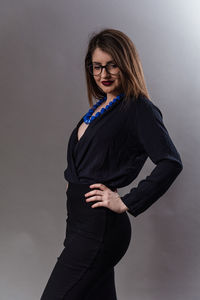 Beautiful young woman standing against wall