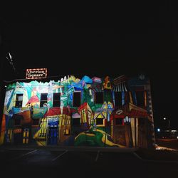 Illuminated ferris wheel against sky at night