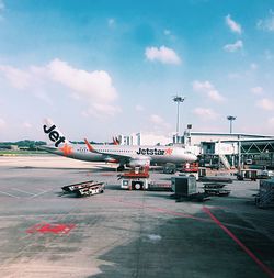 Airplane on airport runway against sky