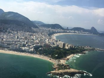 High angle view of city by sea against sky