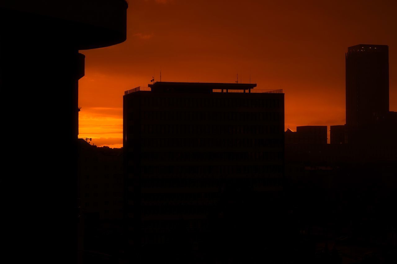 SILHOUETTE BUILDINGS AGAINST ORANGE SKY