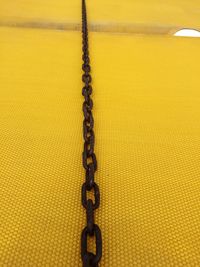 High angle view of chain on yellow floor at harbor