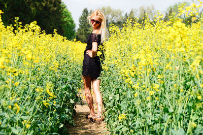 Full length of young woman standing on dirt road