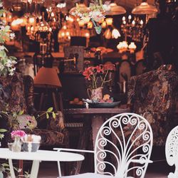 Chair by table against illuminated coffee shop